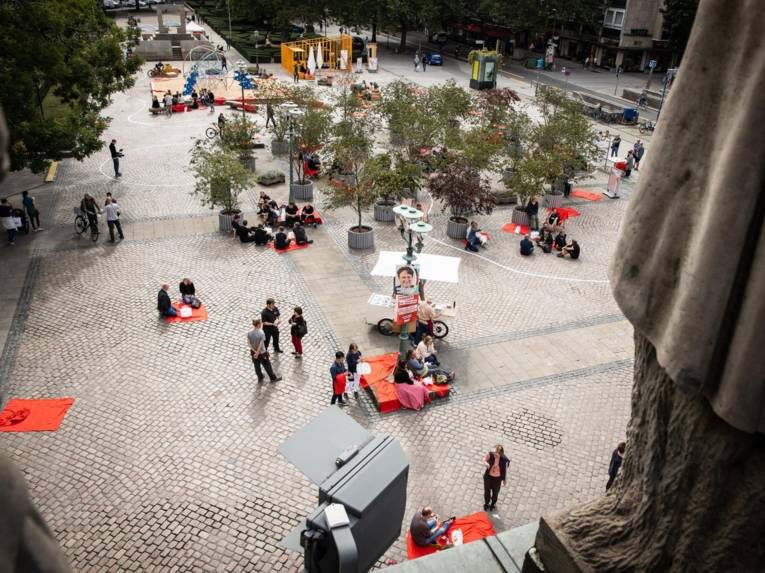 Menschen beim Picknick auf einem Platz.